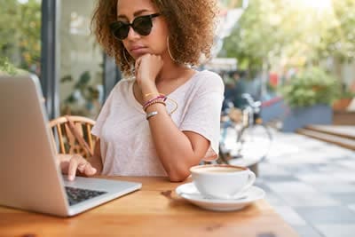 woman-at-cafe-reading-emails Woman at cafe coffee shop reading email